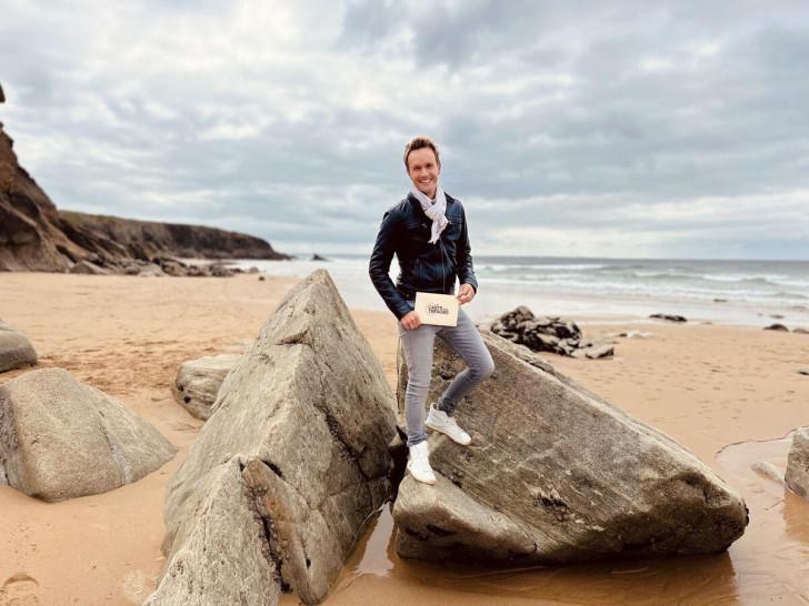 Cyril Féraud pose entre deux rochers sur une plage morbihannaise